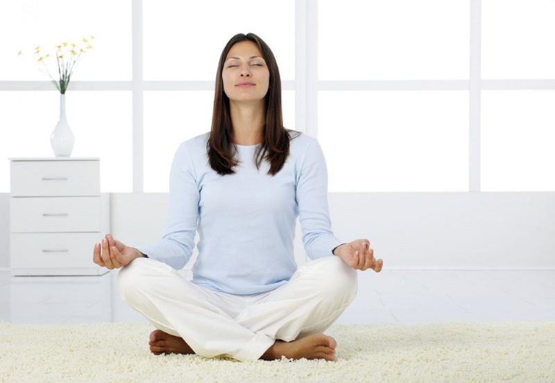 Hình ảnh một người phụ nữ đang thực hiện tư thế con thuyền trong yoga, cho thấy sự tập trung và tác động vào cơ bụng. Phòng tập yên tĩnh, ánh sáng tự nhiên.